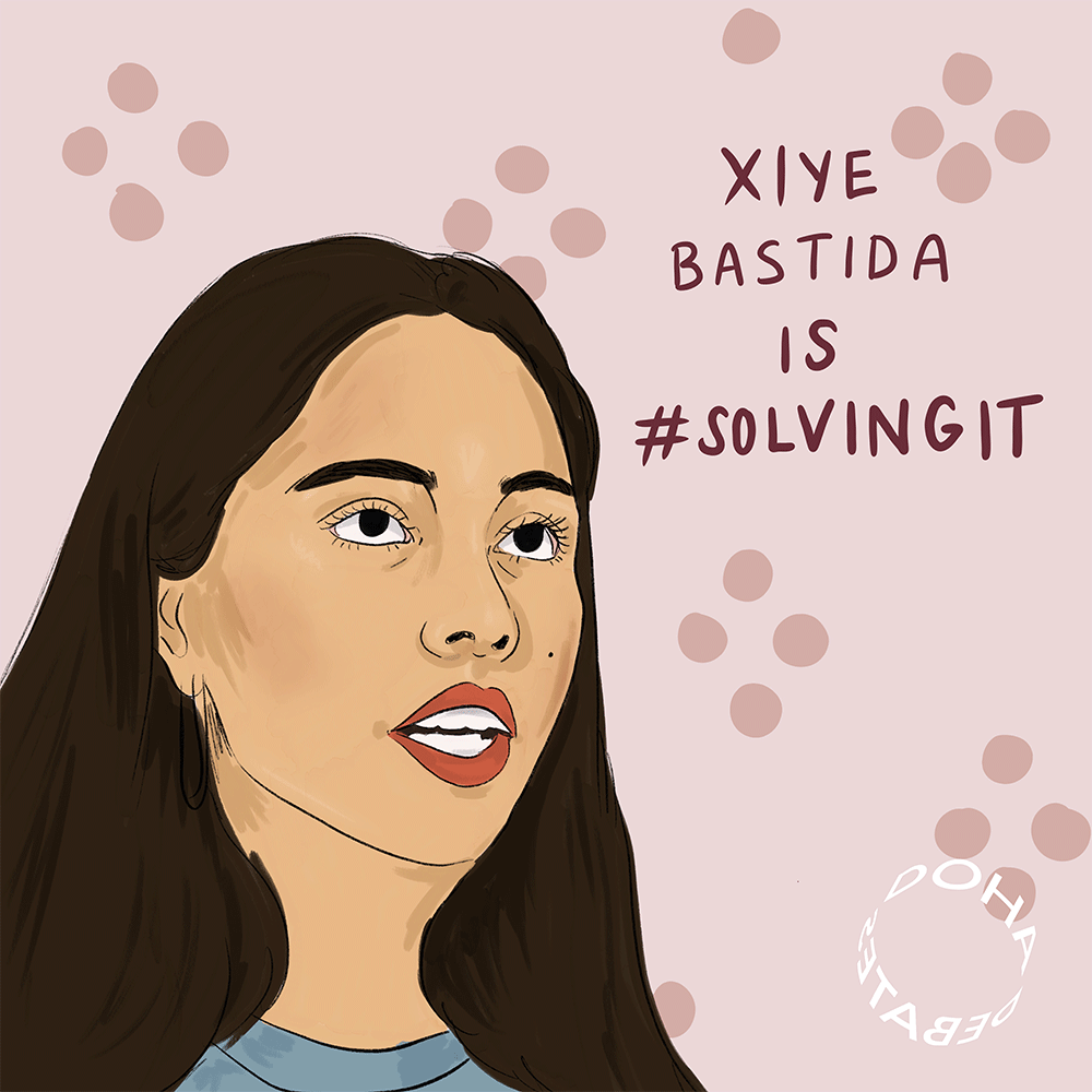 Illustration of a woman in long dark hair wearing a blue shirt. She is sitting against a pink-colored background with rose-colored circles. Text over image reads, "Xiye Bastida is #SolvingIt."